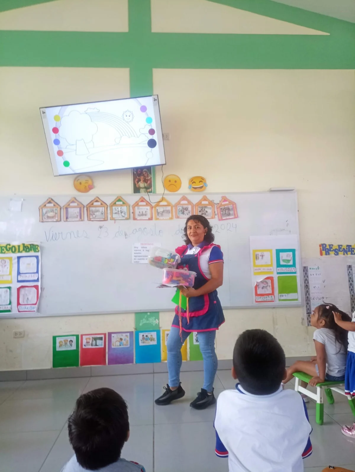Maestra presentando materiales a los niños en el aula